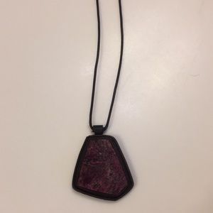 Semi-precious dark pink stone on a leather cord